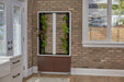 "Walnut Aeva indoor garden situated in a kitchen with a brick wall, featuring leafy green vegetables growing