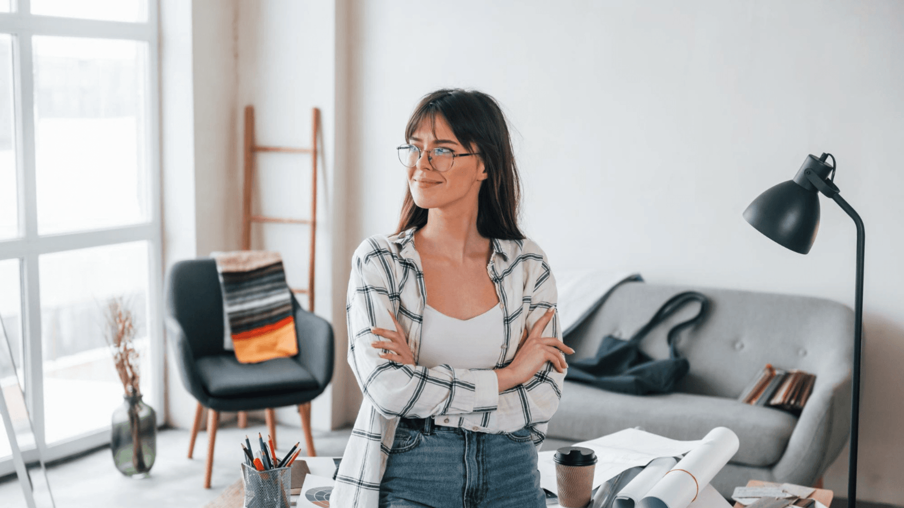 Photo standing near table young female freelance worker is indoors in home at daytime