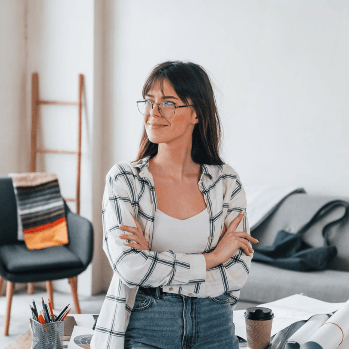 Photo standing near table young female freelance worker is indoors in home at daytime